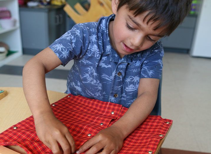 Young boy exploring textures at daycare | Bright Horizons | Montessori