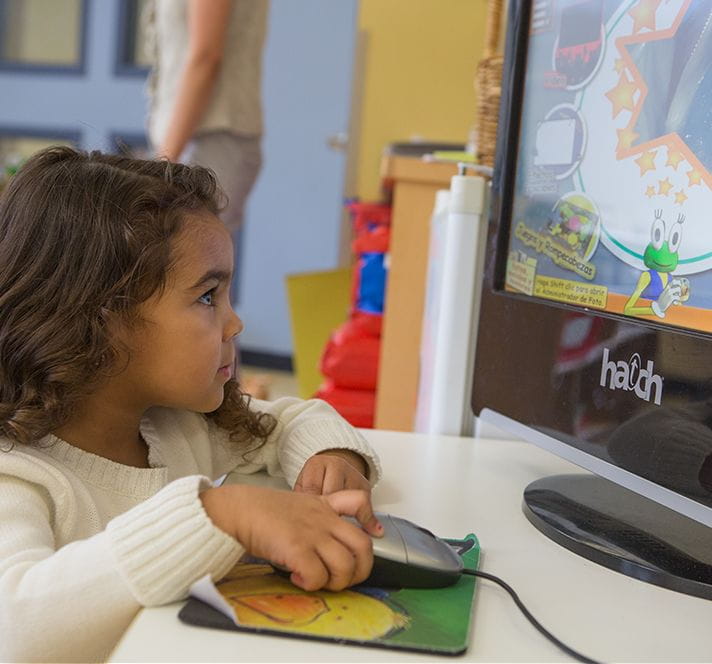 Kindergarten Prep girl with brown hair playing educational games on a desktop computer