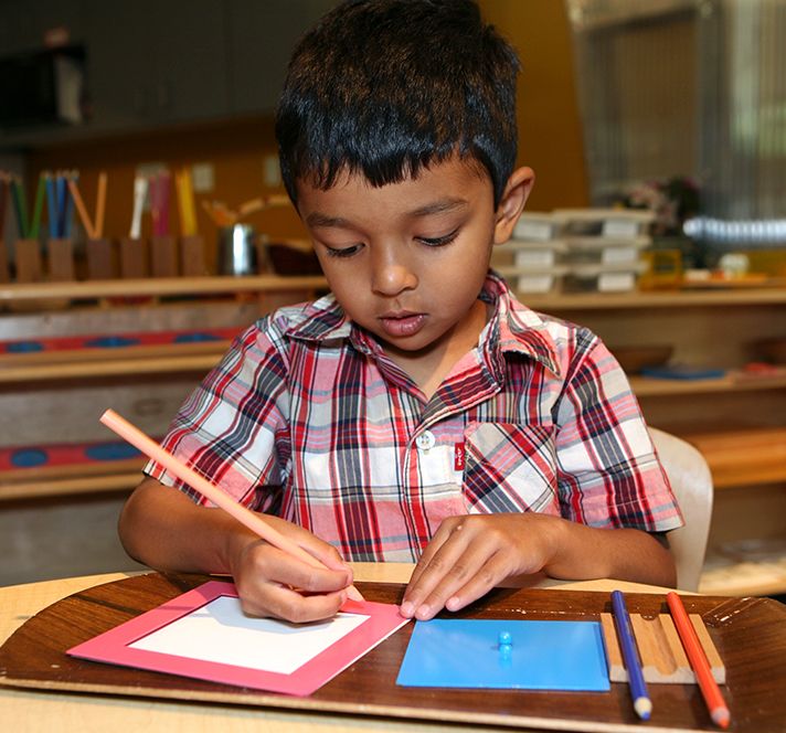 Kindergarten Prep boy practicing his writing at a desk