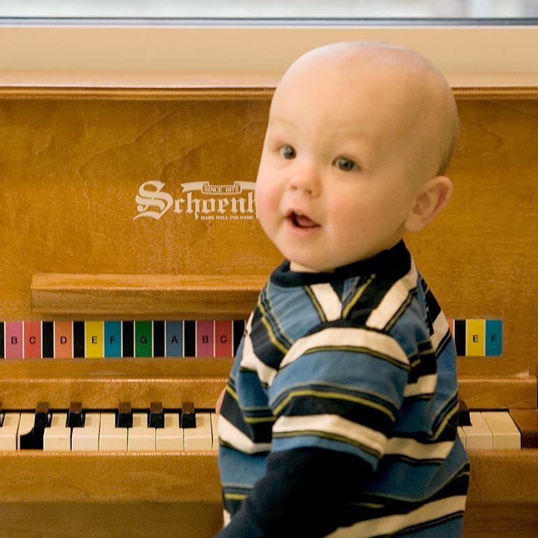 Bright Horizons infant playing with a piano