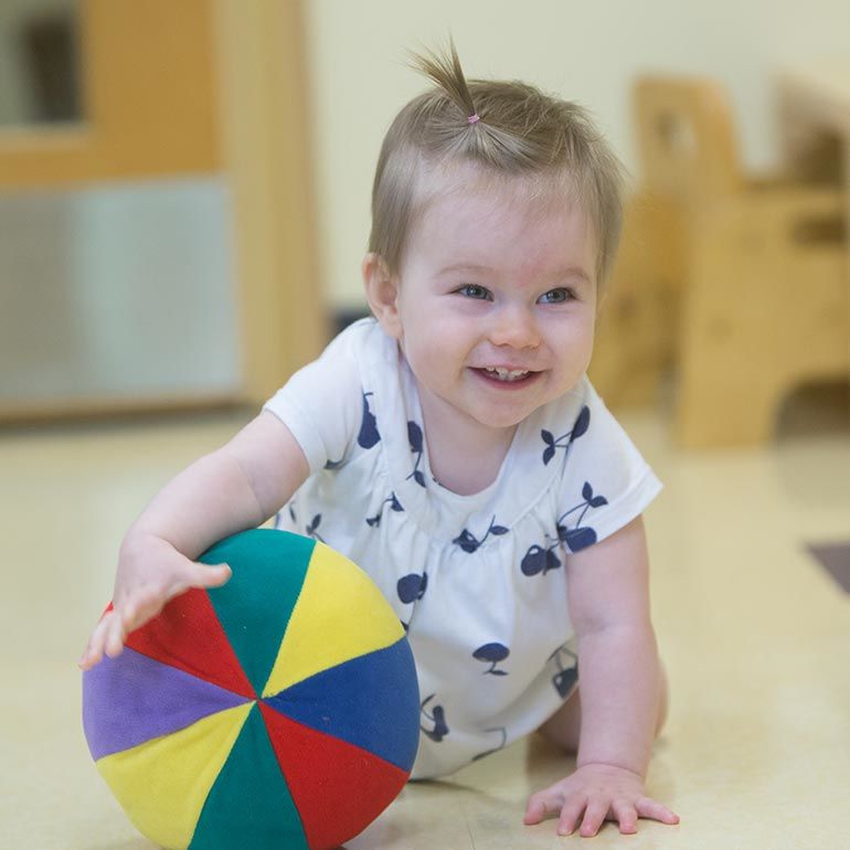 Bright Horizons infant playing with a ball