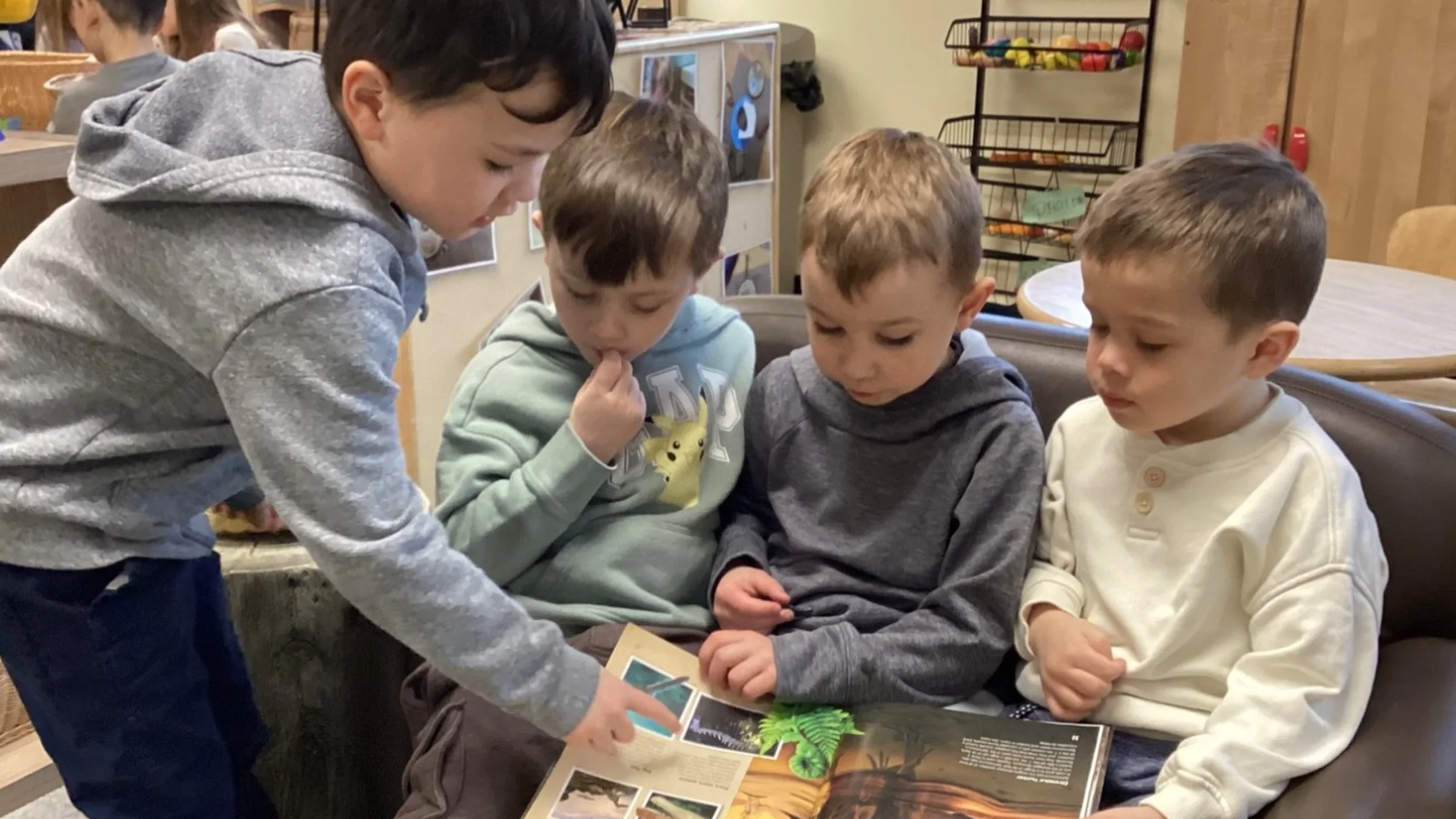Four boys reading a picture book