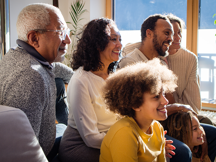 Five people sitting together in a bright room with large windows ?? 