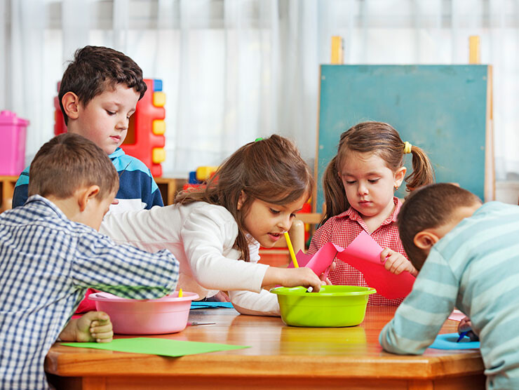 Kindergarteners playing arts & crafts in a classroom