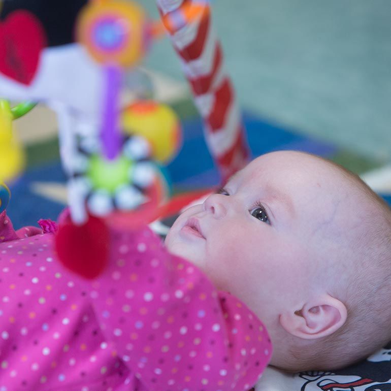 Bright Horizons infant playing with a mobile