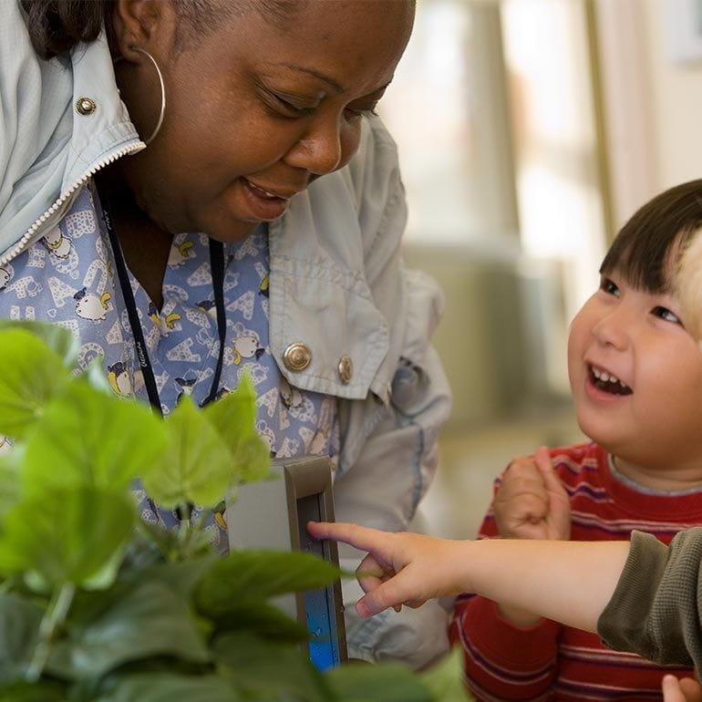 Bright Horizons Toddler student and teacher observing a plant