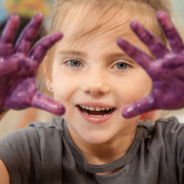 Small child with purple paint on their hands