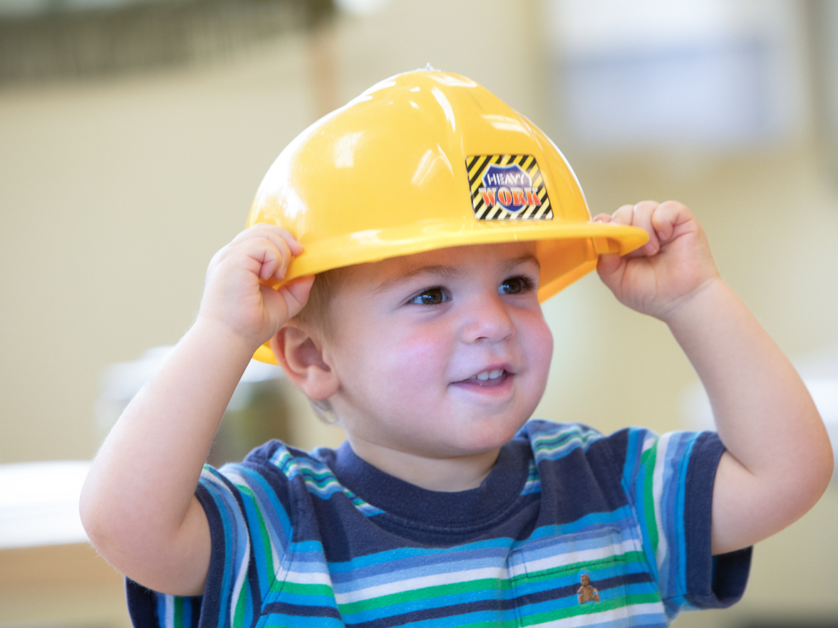 Child wearing a toy safety helmet